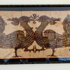 May include: Framed artwork featuring two stylized birds facing each other. The birds have intricate patterns in brown, gold, and red hues against a beige background. The artwork is encased in a black bamboo-style frame, adding a touch of elegance.
