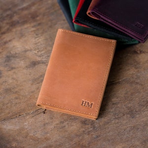 May include: A brown leather wallet with the initials "HM" embossed on the front.