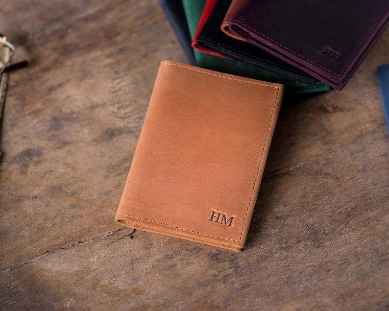 May include: A brown leather wallet with the initials "HM" embossed on the front.