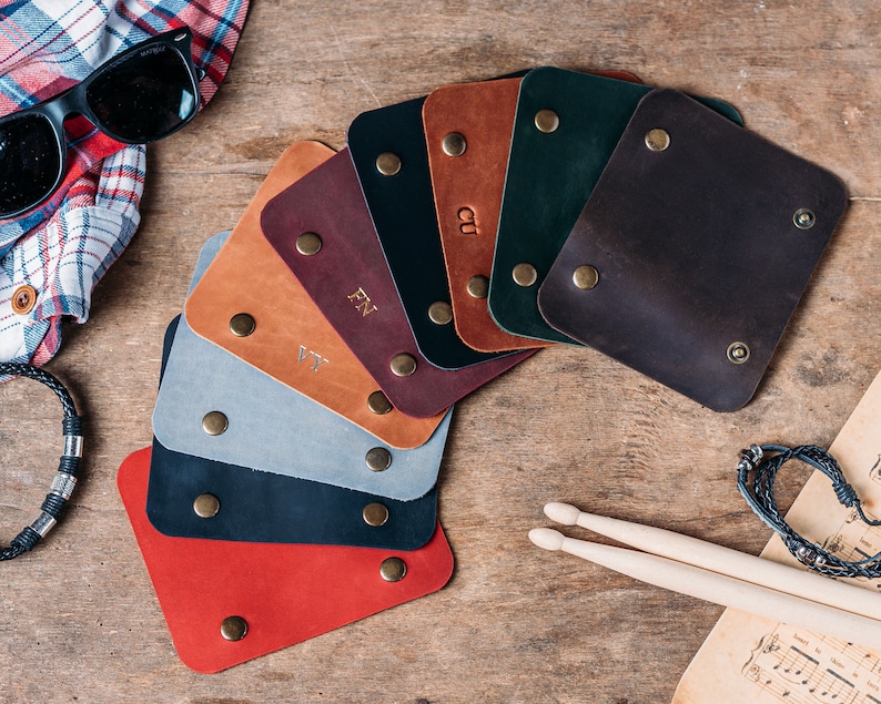 May include: A selection of leather swatches in various colours, including red, brown, black, grey, and green. The swatches are arranged in a fan shape and have small metal rivets around the edges.