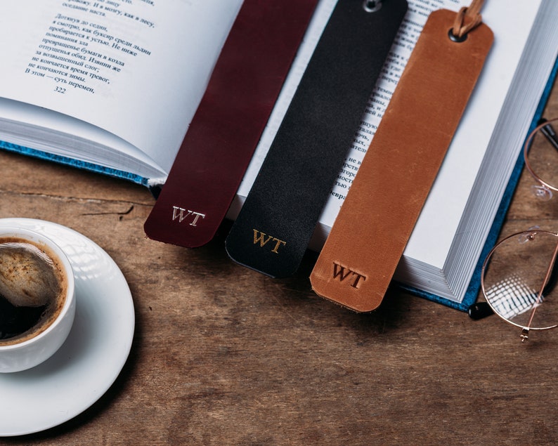 May include: Three leather bookmarks with gold lettering that reads "WT". The bookmarks are burgundy, black, and brown.