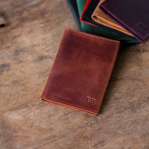 May include: A brown leather wallet with the initials "EB" embossed on the front.