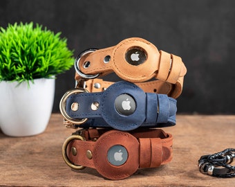 May include: Three leather dog collars with an apple logo in the centre of each. The collars are stacked on top of each other, with the brown collar on top, the blue collar in the middle, and the brown collar on the bottom.