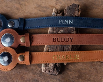 May include: Three leather camera straps with personalised names: Finn, Buddy, and Charlie. The straps are brown and blue with a circular leather attachment.