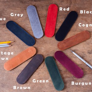 May include: Assortment of 10 leather pencil cases in various colours, including blue, grey, red, black, cognac, vintage brown, brown, green, burgundy.