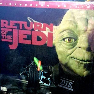 May include: A DVD box set for "Return of the Jedi" featuring Yoda's face and Darth Vader with a lightsaber. The title is in red letters on a black background. The THX logo is visible.