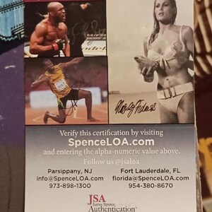 May include: A JSA Basic Certification document with the certification number UU15869. The document includes images of athletes and celebrities, along with their signatures. The James Spence Authentication logo is visible.