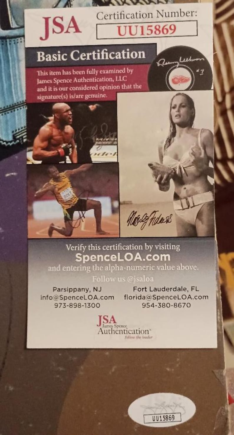 May include: A JSA Basic Certification document with the certification number UU15869. The document includes images of athletes and celebrities, along with their signatures. The James Spence Authentication logo is visible.
