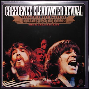 May include: A black and white album cover with the text "Creedence Clearwater Revival Featuring John Fogerty Chronicle The 20 Greatest Hits". The cover features a close-up of four men, three of whom are looking at the camera. The man in the foreground is singing into a microphone.
