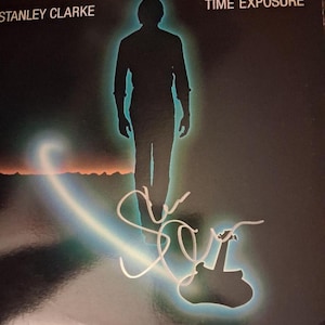 Pode incluir: Capa do álbum "Time Exposure" de Stanley Clarke. A capa apresenta uma silhueta de uma pessoa com um contorno brilhante, em um fundo escuro com um rastro de luz e uma silhueta de guitarra. O nome do artista e o título do álbum estão no topo.