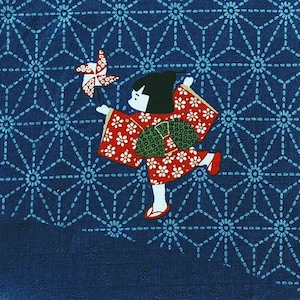 May include: A blue fabric with a white geometric pattern and a red and white illustration of a girl holding a pinwheel.