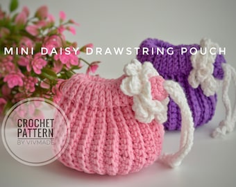 May include: Two crocheted drawstring pouches, one pink and one purple, with white crocheted flowers on top. The pouches are on a white surface. "CROCHET PATTERN BY VIVMADE" is written in a circle on the image.