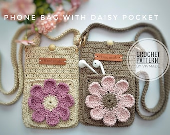 Op de afbeelding: Twee handgemaakte gehaakte telefoontassen met madeliefjeszakken. Eén is beige met een paarse madelief, de andere is bruin met een roze madelief. Elke tas heeft een leren label met "Hand made".
