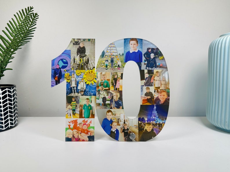 May include: A white wooden number 10 with a collage of photos of a child. The photos are arranged in a grid pattern and show the child at different ages and in different settings.