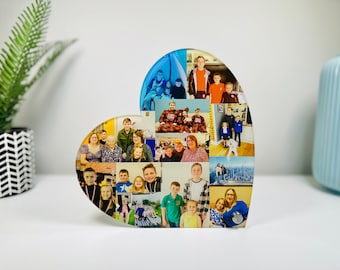 May include: A heart-shaped photo collage with a clear acrylic base. The collage features a variety of photos of a family, including children, adults, and a dog. The photos are arranged in a grid pattern and are printed in color.