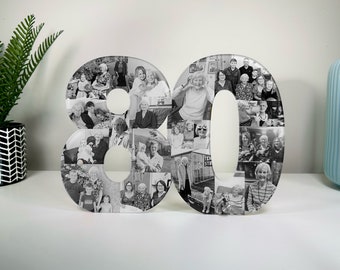 May include: Black and white photo collage of a family in the shape of the number 80. The photos are arranged in a grid pattern and show a variety of people, including children, adults, and seniors.