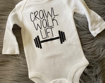 Crawl Walk Lift. Lifting Mom. Lifting Dad. Lifting Baby. Baby that lifts. Fitness baby. Fitness mom. Fitness dad. Workout Baby bodysuit