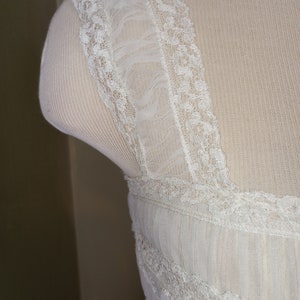 May include: White lace trim with a ruffled edge. The lace is delicate and intricate, with a floral pattern.