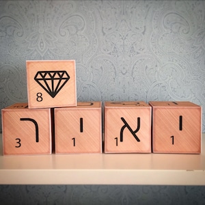 May include: Five wooden blocks with Hebrew letters and numbers. The top block has a diamond symbol and the number 8. The other blocks have the numbers 3, 1, 1, and 1.