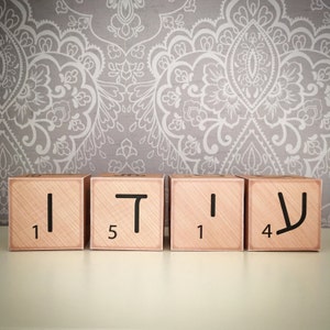 May include: Four wooden blocks with letters and numbers on them. The blocks spell out the word "TIV" and the numbers are 1, 5, 1, and 4.