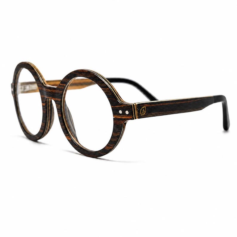 May include: Round eyeglasses featuring a dark brown and black layered wood grain frame. The temples are connected to the circular rims with small silver-toned metal hinges and rivets. A small leaf-shaped logo is engraved on the temple arm.