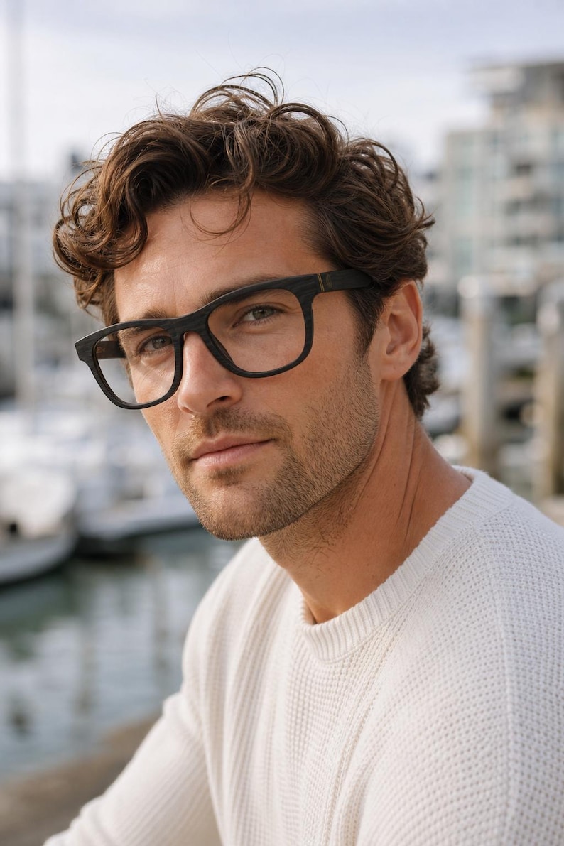 May include: A pair of eyeglasses featuring a dark, wood-grain textured frame with a rectangular shape. The glasses have thick rims and a bridge that connects the two lenses, showcasing a natural, matte finish on the material of the frame.