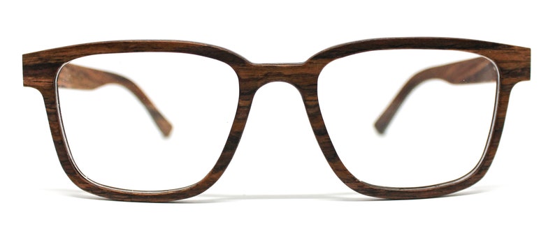 K&ouml;nnte beinhalten: Brille mit einem rechteckigen Rahmen in dunkelbrauner Holzmaserung. Der Rahmen verf&uuml;gt &uuml;ber einen Steg, der die beiden Gl&auml;ser verbindet, sowie zwei B&uuml;gel, die sich zu den Seiten erstrecken. Das Design zeigt eine nat&uuml;rliche Holzstruktur.
