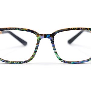May include: Eyeglasses featuring a rectangular frame with a multicolored iridescent abalone shell pattern in shades of blue, green, and purple. The frames have a glossy finish and are paired with solid black temples extending from the sides.