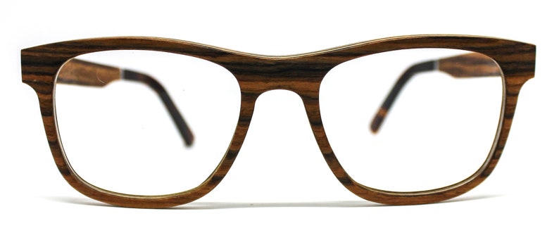 May include: Eyeglasses featuring a frame with a distinct brown and black wood grain pattern. The glasses have a classic rectangular shape with a bridge and two temples that extend backward, showing a dark interior finish on the temple arms.
