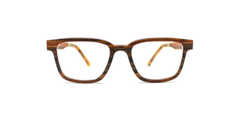 K&ouml;nnte beinhalten: Brille mit rechteckigem Rahmen in dunkelbrauner und schwarzer Holzmaserung. Die B&uuml;gel sind durch die klaren Gl&auml;ser sichtbar und zeigen auf der Innenseite ein hellbraunes und gelbes Muster, das an Schildpatt erinnert.