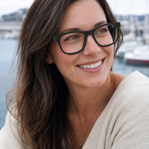 May include: Black rectangular eyeglasses with a thick frame and clear lenses. The frames feature a matte finish and a simple, structured design that sits across the bridge of the nose. The glasses have a classic shape with slightly rounded corners.