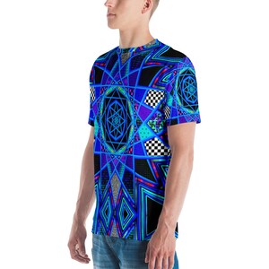 K&ouml;nnte beinhalten: Ein kurz&auml;rmeliges T-Shirt mit einem lebendigen geometrischen Design. Das Shirt zeigt ein komplexes Muster aus blauen, lila und schwarzen Formen, darunter Sterne, Diamanten und Schachbrettquadrate. Das Design ist auf wei&szlig;em Stoff gedruckt.