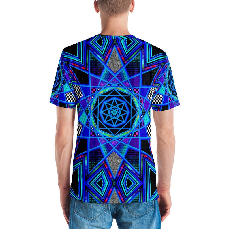 K&ouml;nnte beinhalten: Ein kurz&auml;rmeliges T-Shirt mit einem lebendigen geometrischen Design. Das Shirt zeigt ein komplexes Muster aus blauen, schwarzen und silbernen Formen, darunter Sterne, Diamanten und karierte Akzente. Das Design ist symmetrisch und bedeckt das gesamte Shirt.