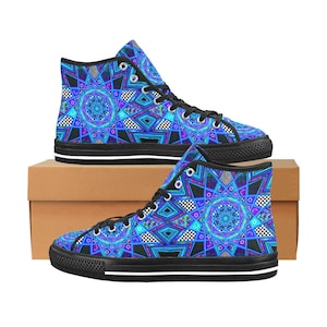 Può includere: Sneakers alte in tela con un vivace motivo geometrico nei toni del blu, viola e verde acqua. Il design include forme di stelle e triangoli, con lacci neri e suola in gomma nera. Le scarpe sono esposte su una scatola di cartone.