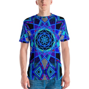 Op de afbeelding: Een t-shirt met korte mouwen met een geometrisch ontwerp in blauw, zwart en blauwgroen. Het patroon bevat stervormige vormen, ruitpatronen en geblokte accenten. Het shirt is gemaakt van een zacht materiaal.