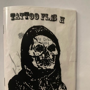 May include: Black and white illustration of a hooded skull with the text "TATTOO FLASH" at the top of the page.