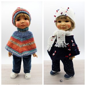 May include: Two dolls wearing knitted winter outfits. The doll on the left is wearing a blue, orange, and grey striped poncho, a blue knit hat, and blue jeans. The doll on the right is wearing a navy blue poncho with white and red accents, a white knit hat with red and blue accents, and navy blue pants with white polka dots.