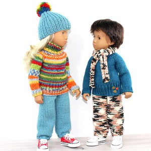 May include: Two dolls wearing knitted clothing. The doll on the left is wearing a blue hat with a pom-pom, a multi-coloured striped jumper, blue trousers, and red trainers. The doll on the right is wearing a blue jumper with a scarf, camouflage trousers, and white trainers.