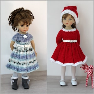 Puede incluir: Dos muñecas con vestidos de punto. La muñeca de la izquierda lleva un vestido a rayas azules y blancas con un copo de nieve blanco en la parte delantera. La muñeca de la derecha lleva un vestido rojo con ribete blanco y un gorro de Papá Noel blanco.