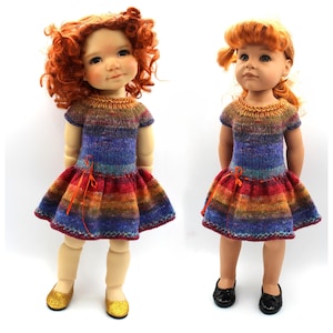 May include: Two dolls dressed in rainbow-striped knitted dresses with short sleeves and flared skirts. The dresses display a spectrum of colours, including red, orange, yellow, blue, and purple. One doll wears gold glitter shoes, and the other wears black shoes. Both dolls have red hair.