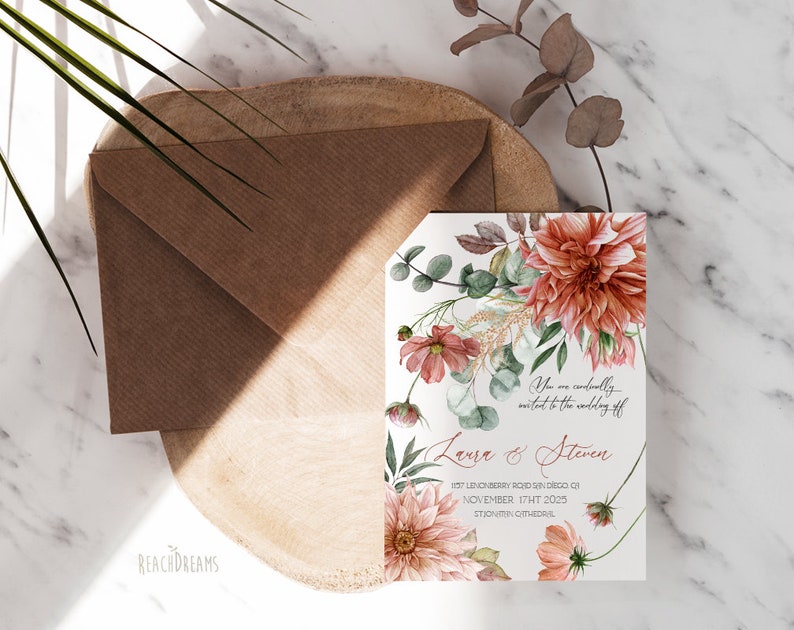 Peut inclure: Une invitation de mariage avec un motif floral compos&eacute; de fleurs roses et p&ecirc;che, de feuilles vertes et d'accents dor&eacute;s. Le texte indique "Vous &ecirc;tes cordialement invit&eacute;s au mariage de Laura & Steven 1157 Lenonberry Road, Shindeco, CA 17 novembre 2025 Cath&eacute;drale Saint-Jovinin."