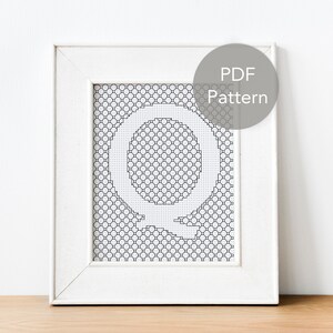 Peut inclure: Un cadre blanc avec un motif de point de croix noir et blanc de la lettre Q. Le cadre a un fond blanc et un passe-partout blanc. Un cercle gris avec le texte "PDF Pattern" est dans le coin supérieur droit de l'image.