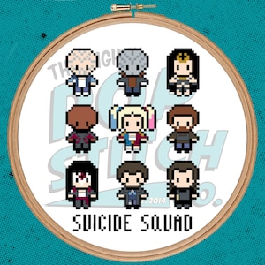 Può includere: Un telaio per punto croce con personaggi pixelati di Suicide Squad. I personaggi sono disposti in una griglia, con le parole "SUICIDE SQUAD" in basso. Il telaio è in legno e ha uno sfondo bianco.