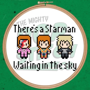 May include: A white embroidery hoop with a green background. The hoop contains a pixelated image of three cartoon figures with the text "The Mighty There's a Starman Waiting in the Sky".