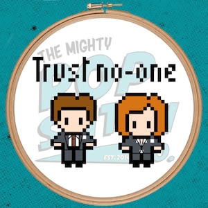Könnte beinhalten: Gestickte Hoop-Kunst mit pixelartigen Figuren aus der Fernsehserie "Akte X" mit dem Text "The Mighty Pop Stitch" und "Trust no-one".