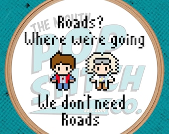 May include: A white embroidery hoop with a brown wooden frame. The hoop features a pixelated image of two characters from the movie Back to the Future. The text "The Mighty Pop Stitch Co. Est. 2014" is printed on the hoop. The text "Roads? Where we're going we don't need roads." is printed above the characters.