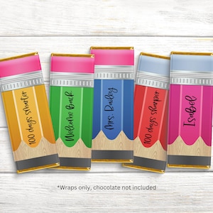 May include: Five colorful pencil-shaped chocolate bar wrappers. Each wrapper has a different color, including yellow, green, blue, red, and pink. The wrappers have text such as "100 days smarter" and "Welcome Back".