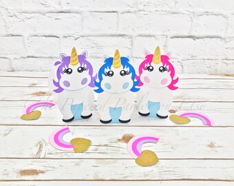 May include: Three unicorn-shaped party favor boxes with gold horns and rainbow accents. The boxes are purple, blue, and pink.