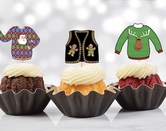 May include: Three cupcakes decorated with festive Christmas sweater toppers. The cupcakes are in black cupcake liners. The toppers are a red and green sweater with a Santa Claus, a black sweater with gingerbread men, and a green sweater with a reindeer.