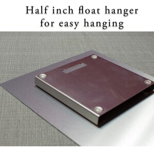 May include: A close-up of the back of a metal print showing a half-inch float hanger for easy hanging.